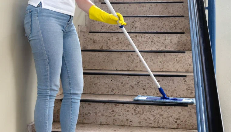 Apartman merdivenlerini temizleyen görevli