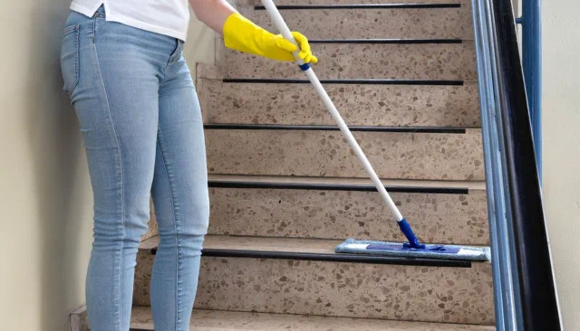 Apartman merdivenlerini temizleyen görevli